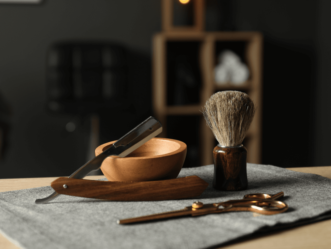 Close-up of barbering tools including a razor, brush, and scissors, set on a barber’s cloth at John Richards Hairdressing, Allington, Maidstone.