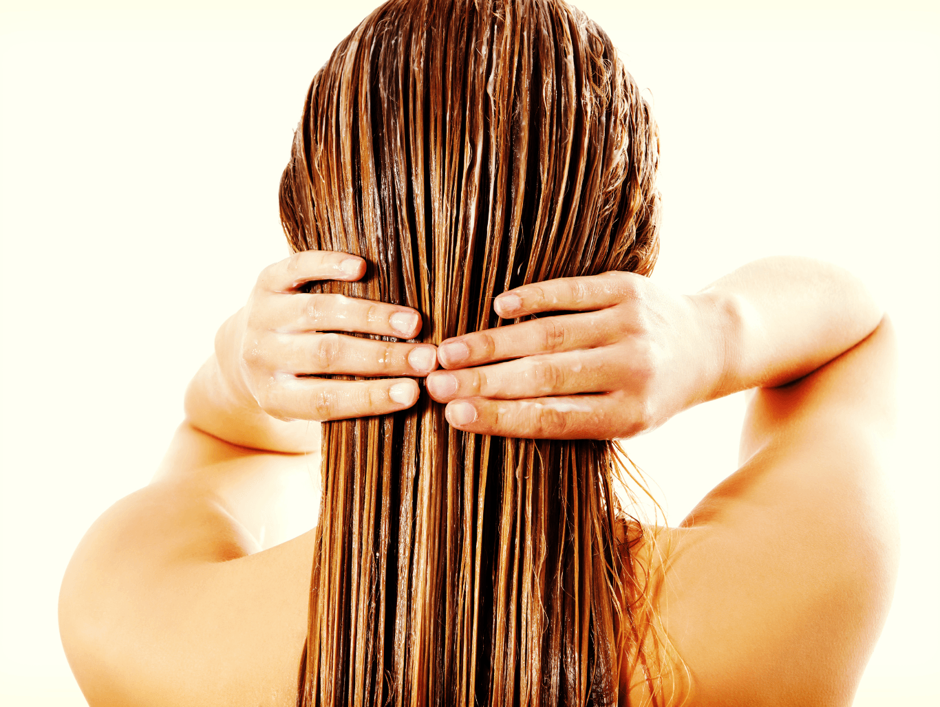 Back view of a woman applying a rich conditioning treatment, showcasing healthy, nourished hair at John Richards Hairdressing, Allington, Maidstone.