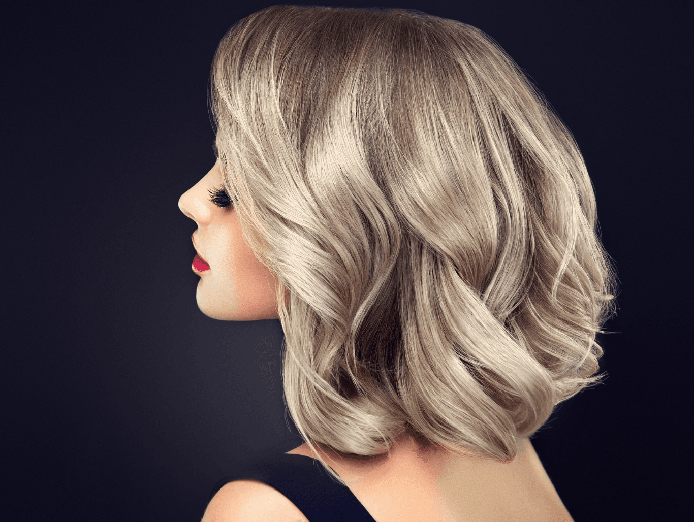 Woman with softly curled, highlighted blonde hair, showcasing expertly applied half head highlights at John Richards Hairdressing, Allington, Maidstone.