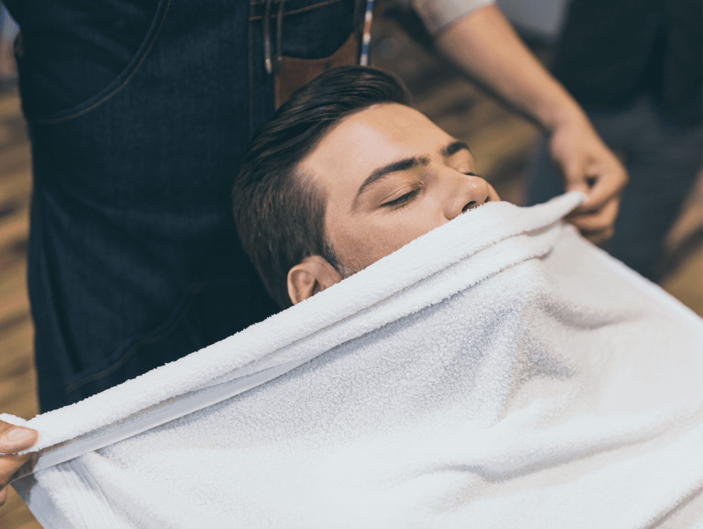 Man enjoying a relaxing hot towel wet shave at John Richards Hairdressing in Allington, Maidstone, showcasing traditional barbering techniques.