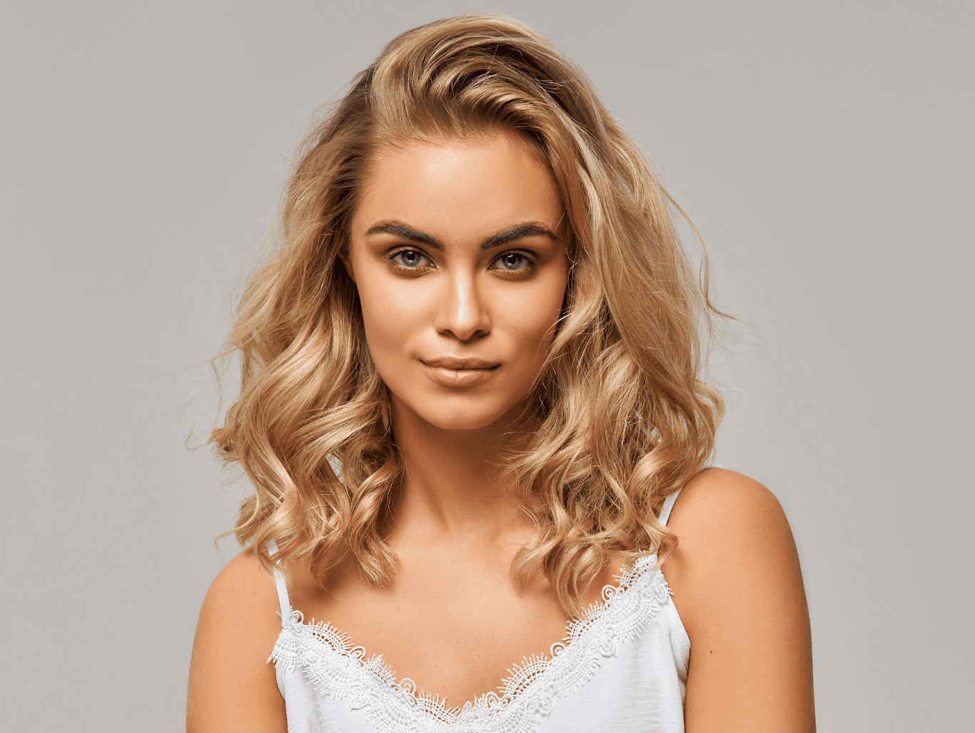 Woman with shoulder-length blonde hair, styled in soft waves, showcasing a professional ladies cut and blow dry at John Richards Hairdressing, Maidstone.